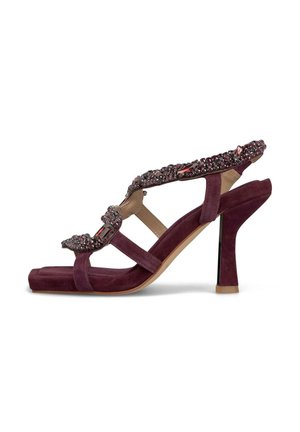 Sandalia de tacón alto de ante morado con correa decorativa que presenta gemas, diseño de punta abierta y un tacón delgado y brillante en negro.