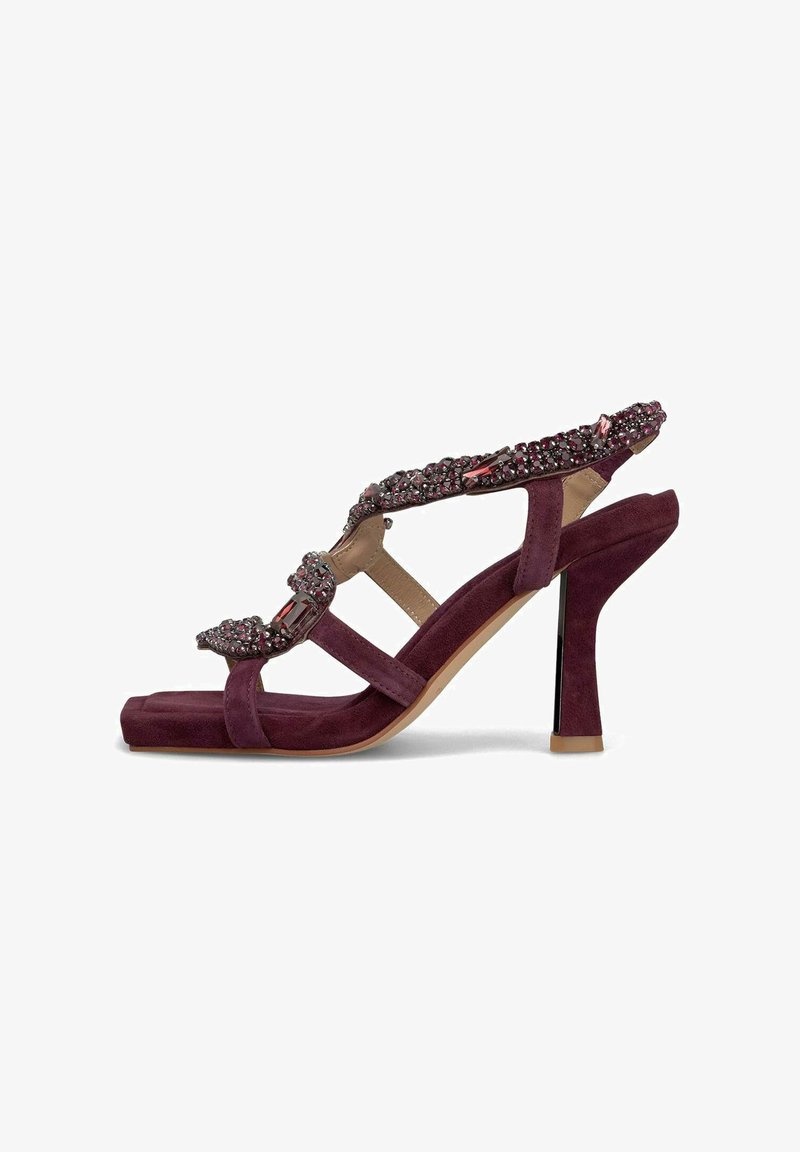 Sandal a tacco alto in suede viola con cinturino decorativo con gemme, design open toe e sottile tacco lucido nero.