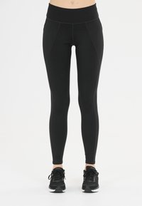 Svart leggings med hög midja, med en slät yta och sömdetaljer. Matcher med svarta träningsskor.