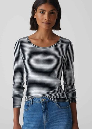 Schwarz-weiß gestreiftes Langarmoberteil mit rundem Ausschnitt, figurbetontem Schnitt und weicher Textur, kombiniert mit blauen Jeans.