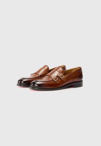 Brown leather loafers with double buckle detail, smooth texture, rounded toe, and black polished accents on the toe and heel.