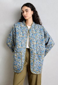 Giacca trapuntata con motivo floreale nei toni blu, beige e oro; presenta un colletto tondo, due tasche e rifiniture a contrasto.
