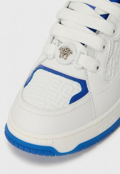 Sneaker bianche con accenti blu, dotate di un pannello testurizzato, con hardware rotondo in argento e lacci bianchi piatti. Suola in gomma con motivo antiscivolo.