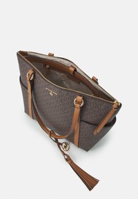 Sac fourre-tout à motifs marron avec des anses en cuir beige, quincaillerie dorée, un accent de frange, fermeture éclair et un intérieur spacieux.