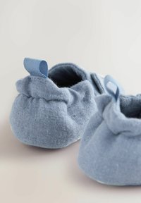 Scarpine per neonati in tessuto azzurro chiaro con design arricciato, tessitura morbida e spiccato anello posteriore per facilitare l'indossamento.