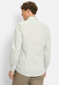 Hellgrün-weiß gestreiftes Langarmhemd mit Kragen, Knopfmanschetten und leicht abgerundetem Saum. Taillierte Passform mit weicher Textur.
