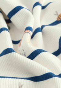 Puuvillane kangas ribakujundusega, millel on vahelduvad kreemjad ja meriini sinised triibud, koos pastelltoodetes lillede ja mesilaste illustreerimisega.