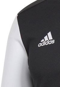 Schwarzes und weißes Sportshirt aus strukturiertem Stoff, mit einem grauen Akzent an der Schulter und einem gestickten Adidas-Logo.