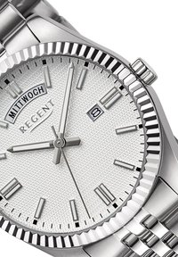 Montre argentée avec un cadran texturé blanc, affichage de la date et bracelet en acier inoxydable. Comprend des index angulaires et une lunette cannelée.