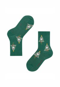 Grüne Socken mit einem gestrickten Design, das cartoonhafte Weihnachtsbäume und weiße Gesichter zeigt. Enthält rote Akzente und Details mit goldenen Sternen.