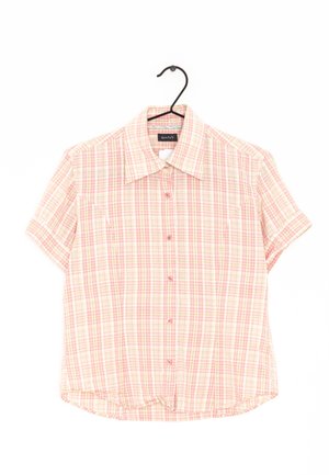 Chemise à manches courtes, à boutons, en tissu léger, présentant un motif à carreaux rose et beige, avec un col classique et deux poches poitrine.