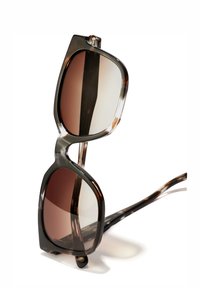 Ochelari de soare supradimensionați cu un model de scoică, lentile de culoare maronie cu gradient, design cu partea de sus plată și temple elegante, curbate.