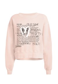 Jasnoróżowy, krojony sweter z miękkiej tkaniny. Posiada nadrukowany tekst związany z baletem oraz grafikę baletowego pantofelka w kolorze czarnym.