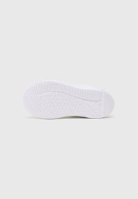 Weiße Sneaker-Sohle mit strukturierter Oberfläche, die ein Rautenmuster für Halt bietet, abgerundete Zehenpartie und eine leichte Erhöhung an der Ferse.