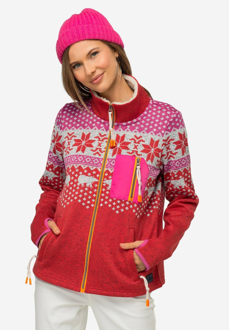 Giacca in pile rossa con un design a fantasia caratterizzato da elementi bianchi e rosa, una tasca con zip rosa e zip e lacci di contrasto arancioni.