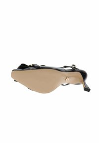 Sandal nera con tacco alto e cinturino sottile, caratterizzata da un design elegante, punta affilata e suola beige che mette in risalto un dettaglio del logo metallico.