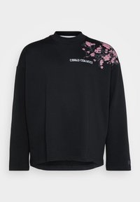 Black sweatshirt with a high neck, featuring pink floral embroidery on the left shoulder and a logo on the front. Soft textured fabric.