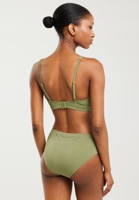 Zestaw bikini w oliwkowym kolorze, składający się z biustonosza na cienkich ramiączkach i zapięciem z tyłu, połączony z wysokim stanem majtek, oba wykonane z gładkiej tkaniny.