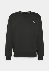 Sweat-shirt noir à manches longues avec col ras du cou, doté de poignets et d'un ourlet côtelés, arborant un petit logo Jumpman blanc sur la poitrine gauche.