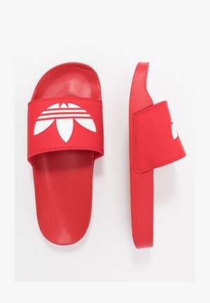 Red slide sandals with a textured strap featuring a white graphic design. The sole is flat and smooth, matching the strap in color.