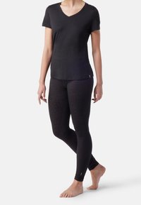 T-shirt nero a maniche corte con scollo a V, realizzato in tessuto morbido, abbinato a leggings neri con un leggero motivo floreale.