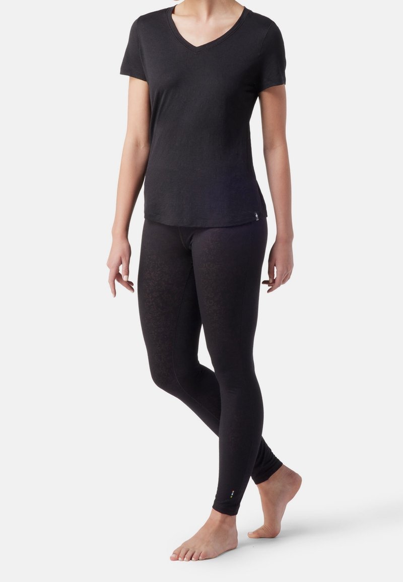 T-shirt nero a maniche corte con scollo a V, realizzato in tessuto morbido, abbinato a leggings neri con un leggero motivo floreale.