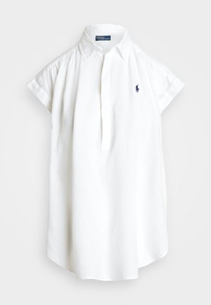 Camisa de lino blanca con cuello tipo punta, mangas cortas y tapeta. Presenta un pequeño logotipo en navy en el pecho. Textura suave y corte relajado.