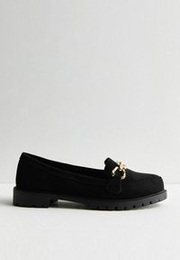 Black suede loafers with a flat rubber sole, featuring a gold-tone hardware accent and a rounded toe design.
