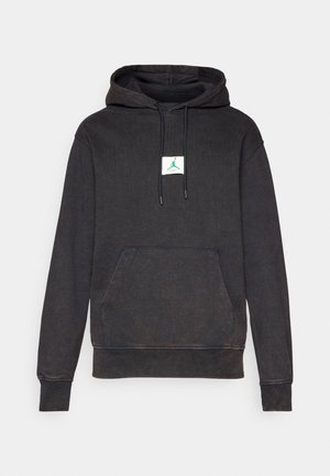Felpa nera in morbido cotone con tasca frontale, cappuccio con coulisse e una patch bianca con un logo verde.