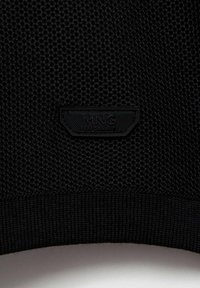 Črn mrežasti material z teksturiranim vzorcem in rebrastim robom. Vključuje oblikovano črno oznako z napisom "MNG PERFORMANCE."