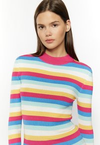 Daugiaspalvis įrankinis megztinis, turintis horizontalius raštus rožinės, mėlynos, geltonos ir baltos spalvų, su aukštu kaklu ir prigludusia forma.