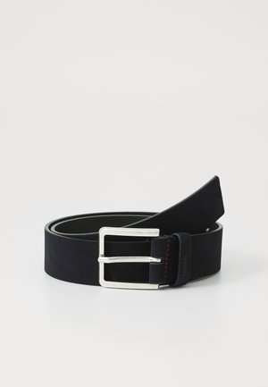 Ceinture en cuir noir roulée avec une boucle rectangulaire en métal argenté sur fond blanc uni.