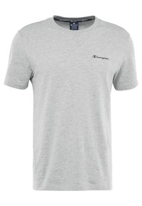 Szary bawełniany t-shirt z krótkim rękawem i okrągłym dekoltem, z małym niebieskim logo Champion na lewej piersi. Gładka faktura.