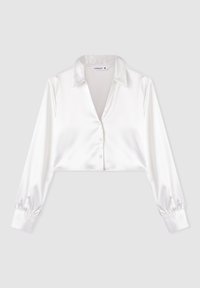 Blusa bianca in satin tagliata, con maniche lunghe a palloncino, colletto a punta e chiusura frontale con bottoni. Tessuto liscio con un leggero lucore.