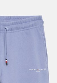 Ανοιχτό μωβ φόρμες με ελαστική μέση, κορδόνι ρύθμισης και εκτυπωμένο λογότυπο σε λευκό χρώμα. Διαθέτει λεπτομέρειες με θετικά χρώματα στα μεταλλικά στοιχεία.