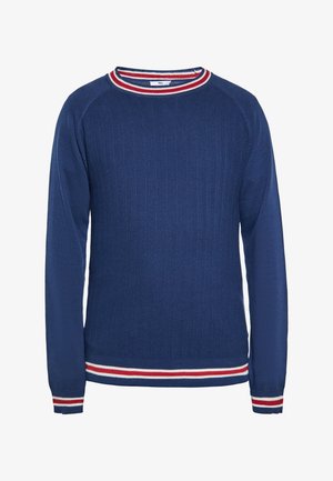Granatowy sweter z długim rękawem, z białym i czerwonym paskowanym wykończeniem na kołnierzu, mankietach i dole, wykonany z fakturowanej dzianiny.
