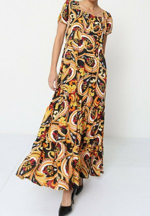 Robe maxi en tissu noir avec un motif paisley vibrant rouge, jaune et vert. Elle présente des manches courtes et un design en couches fluide.