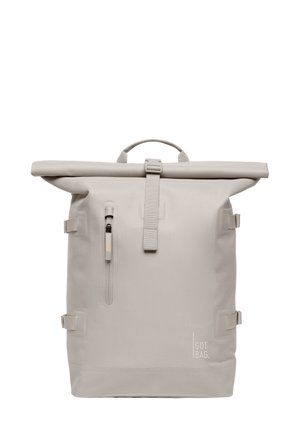 Mochila con cierre enrollable en material gris claro; cuenta con correas, bolsillo con cremallera, lazos y logo de la marca; diseño elegante y minimalista con textura duradera.