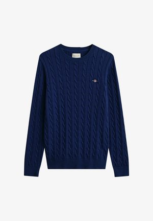 Marineblauwe kabelgebreide trui met ronde hals, lange mouwen en een klein geborduurd logo op de borst.