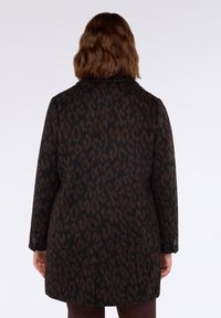 Cappotto nero con stampa leopardata in tonalità marroni, dal taglio dritto, con collo a scollo e polsini abbottonati. Il tessuto appare texturizzato.
