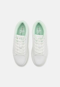 Hvite lær sneakers med en glatt overflate, med en mintgrønn polstret fôr og tunge, samt hvite snørebånd. Merking synlig på innersålene.