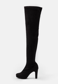 Botas de tacón alto y sobre la thigh en negro, hechas de suave ante, con punta redonda y un tacón grueso. Textura lisa sin adornos visibles.