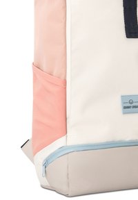 Sac à dos en tissu rose, crème et gris clair ; doté d'une poche latérale et d'une fermeture éclair bleue à la base. Comprend un détail de label "JOHNNY URBAN".