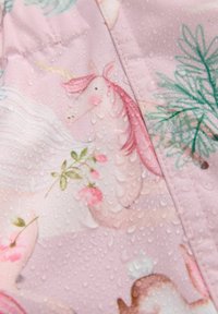 Tessuto resistente all'acqua con uno sfondo rosa, motivo di unicorni, motivi floreali e gocce sulla superficie.