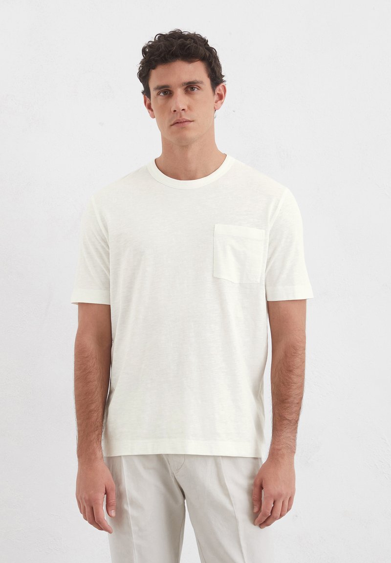 Kurzärmliges, rundhalsiges T-Shirt aus elfenbeinfarbenem Stoff, mit kleiner Brusttasche und relaxed Fit sowie glatter Textur.