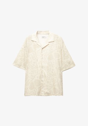 Kortærmet, beige skjorte med et diskret musling- og bølgemønster. Har en krave og knaplukning foran.