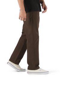 Pantaloni marroni dritti realizzati in tessuto robusto, con una texture liscia e tasche laterali, abbinati a sneakers bianche.
