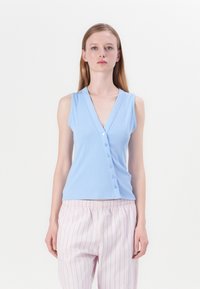 Top de tirantes de color azul claro con canalé, que presenta un escote en V y cierre de seis botones. Combinado con pantalones a rayas de color rosa claro. Textura de tela suave.