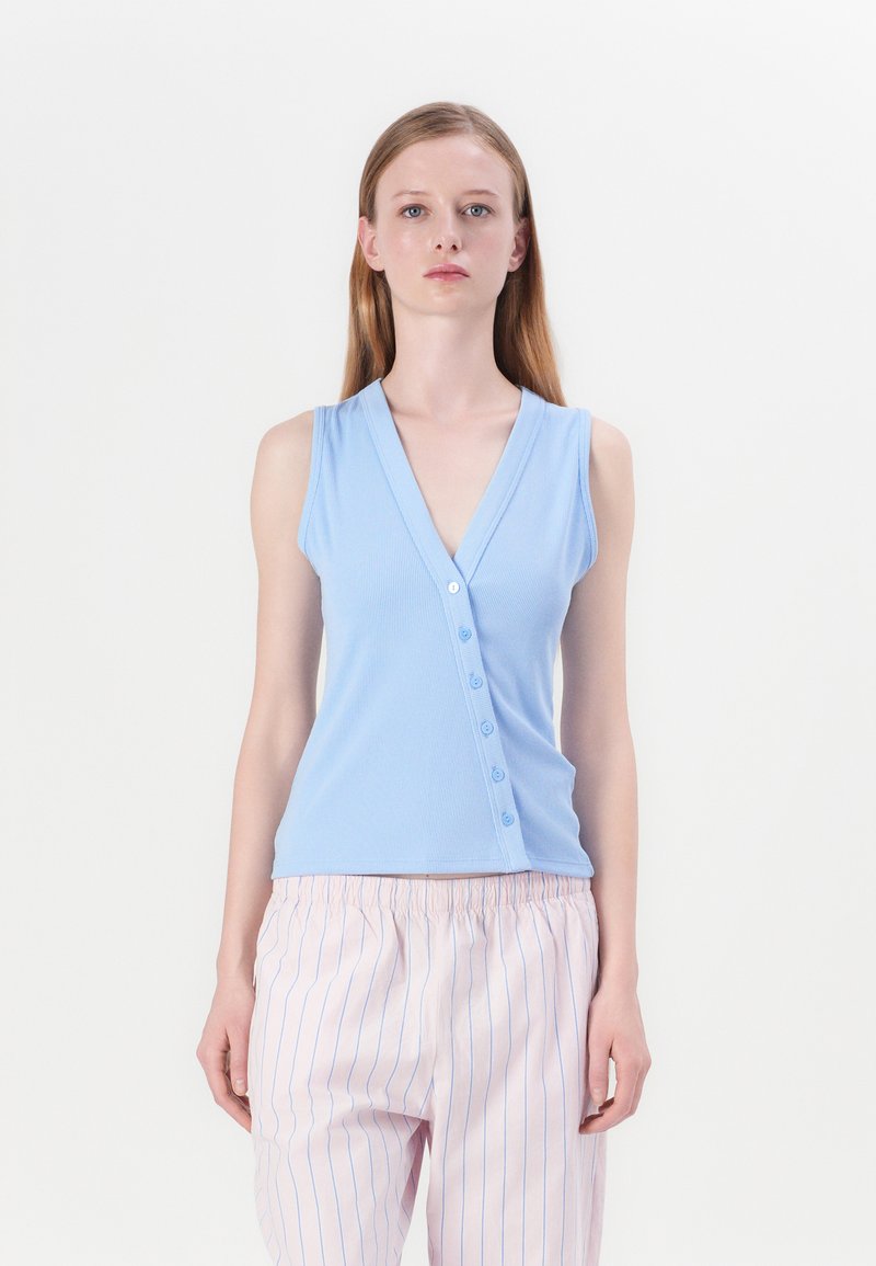 Top de tirantes de color azul claro con canalé, que presenta un escote en V y cierre de seis botones. Combinado con pantalones a rayas de color rosa claro. Textura de tela suave.