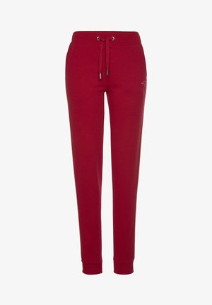 Red sweatpants with a drawstring waistband, tapered legs, and elastic cuffs. Fabric features a smooth texture and subtle logo detail.